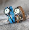 montre en cuir grav&eacute; et breloques