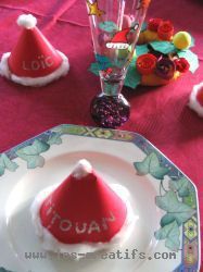 <strong>Un chapeau de Père Noël en marque-place</strong>, réalisé en papier épais rouge, avec du cot <strong>Un chapeau de Père Noël en marque-place</strong>, réalisé en papier épais rouge, avec du cot