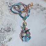  Collier Coquette créé avec deux estampes à laquelle s’ajoute des fleurs en velours floqué, perles aplaties Cristal, fleurs : Epoxy, Porcelaine, Résine, cabochon loupe, rubans et chaîne plaqué Or