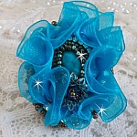Bague Ilycia Charming brodée avec un cabochon facetté Bleu Turquoise, fleur en Cristal, chatons, rocailles Gold et Bronze. Le tout est monté sur un support de bague couleur Or en laiton