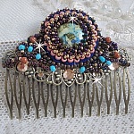 Peigne Bonjour Paris cabochon marbré bleu/vert/écru orné de rocailles en verre dont la couleur dominante est le Violet. Montés sur un peigne Bronze métal avec des perles du Soleil. Un look city !