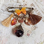 Broche Méline des Bois épingle créée avec rondes strass, pompons, gouttes verre, chaîne et boule de bohème en verre