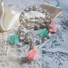 Bracelets Cristalline Eclat avec doubles bracelets aux perles Stardust Argentées effet pailleté, perles rondes facettées en verre et pompons couleur Rose et Menthe pour un style contemporain