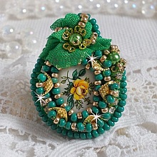 Bague Belle Emeraude brodée avec un cabochon ovale en céramique représentant une rose Jaune sur fond Blanc, un tissu léger de couleur Vert, des perles rondes nacrées et des rocailles Dorées